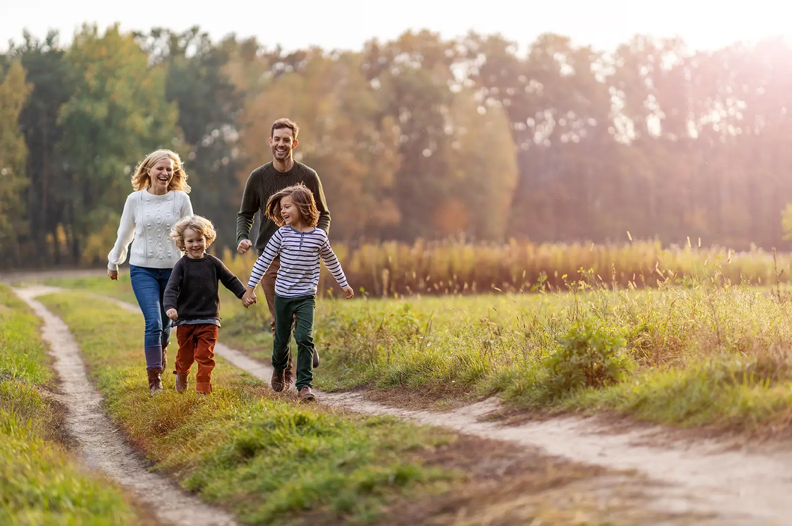 Smiling family of four walking on a sunny trail, representing financial peace of mind in Spring, TX.