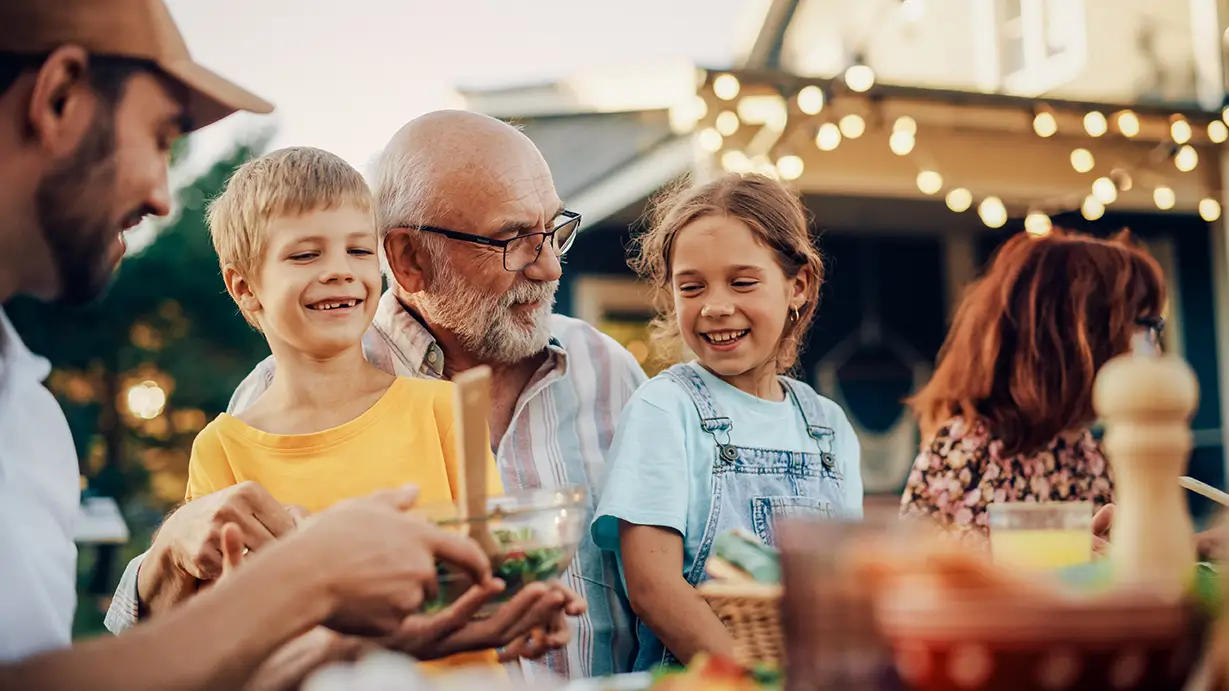 Happy grandfather with grandchildren at family gathering, symbolizing retirement planning in Spring, TX.
