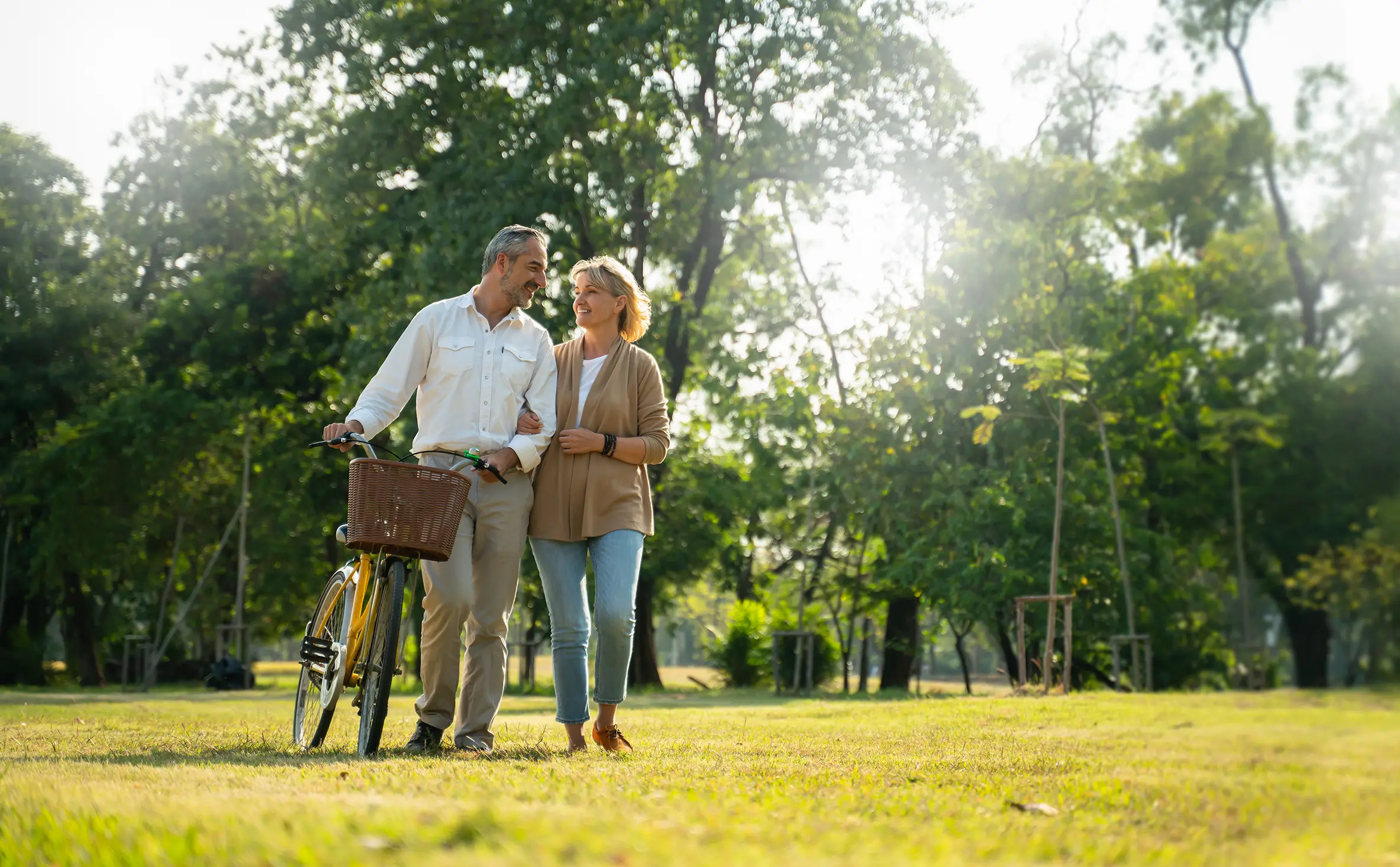 Smiling family of four walking on a sunny trail, representing financial peace of mind in Spring, TX.
